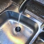 Water down the drain of kitchen sink.