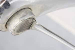 Hard water stains on running sink faucet